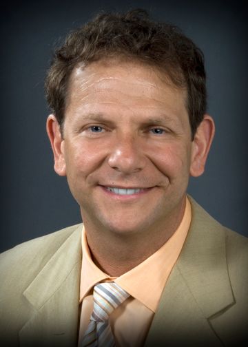 Adam Stein, MD, wearing a light brown suit and peach shirt